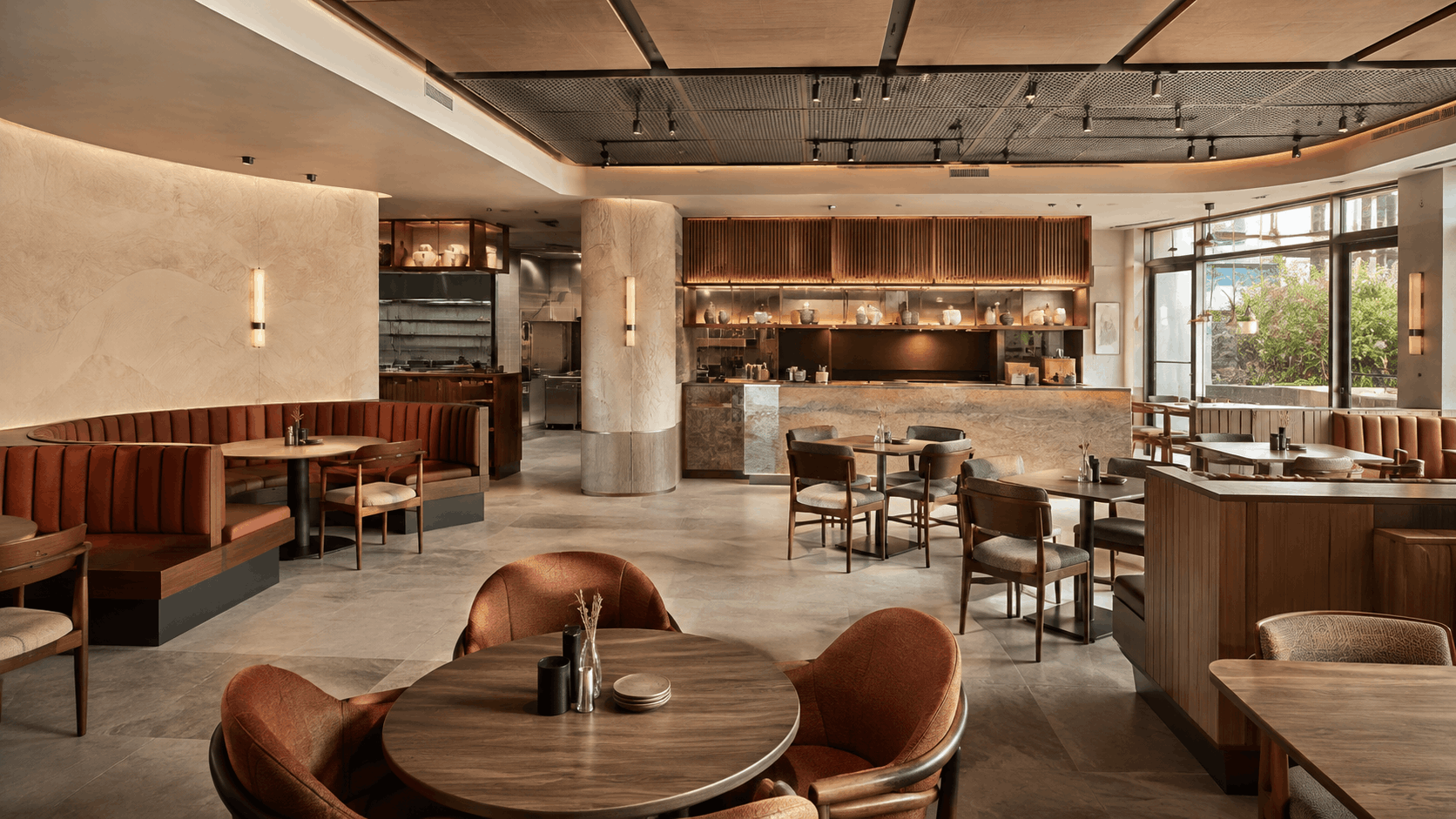 Finished restaurant interior with open kitchen, marble bar counter, and mixed booth and table seating